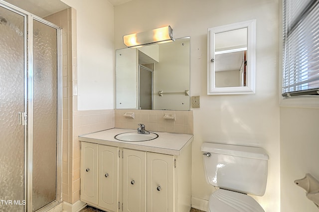 bathroom featuring vanity, a shower with shower door, and toilet