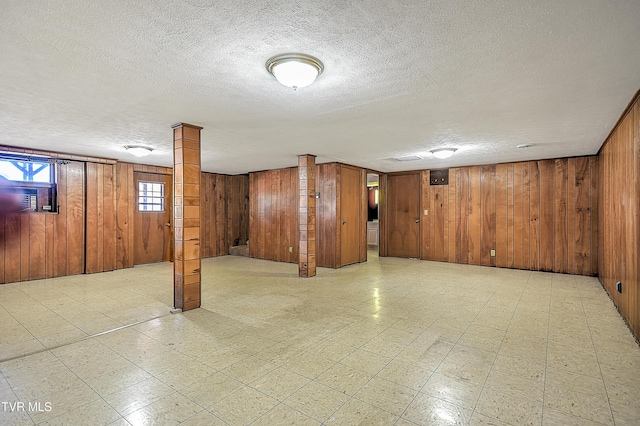 basement with a textured ceiling and wood walls