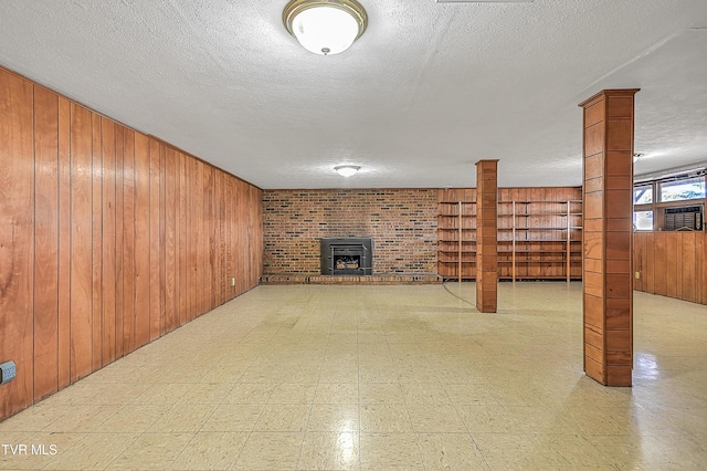 unfurnished living room featuring wood walls, a wood stove, and a textured ceiling