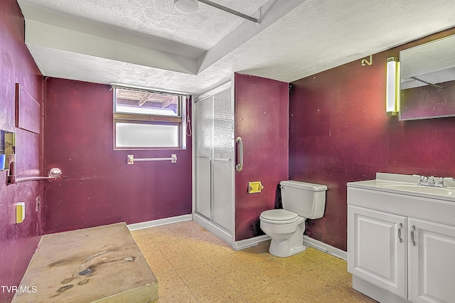 bathroom featuring vanity, toilet, a shower with door, and a textured ceiling