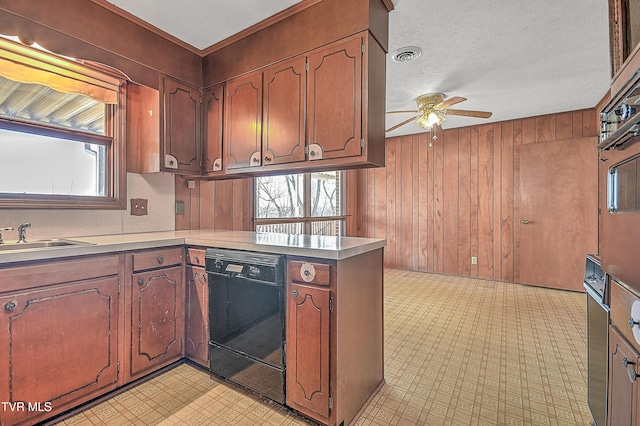 kitchen with kitchen peninsula, ceiling fan, wooden walls, sink, and dishwasher