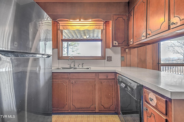 kitchen with sink, black dishwasher, and stainless steel refrigerator