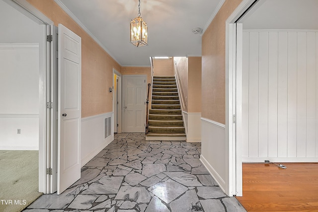 entrance foyer with ornamental molding and a notable chandelier