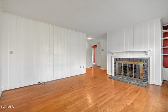 unfurnished living room with a fireplace and light hardwood / wood-style floors