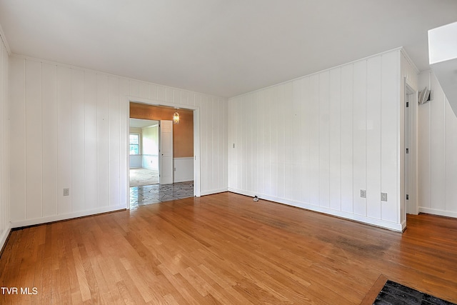 empty room featuring wood walls and wood-type flooring