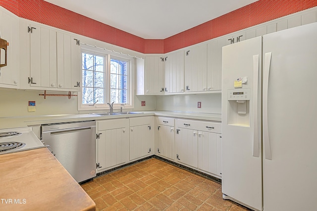 kitchen featuring white refrigerator with ice dispenser, white cabinetry, dishwasher, and sink