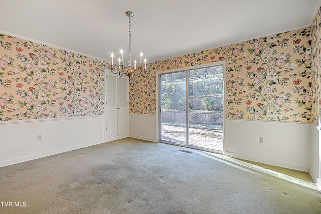 carpeted spare room featuring crown molding and a notable chandelier