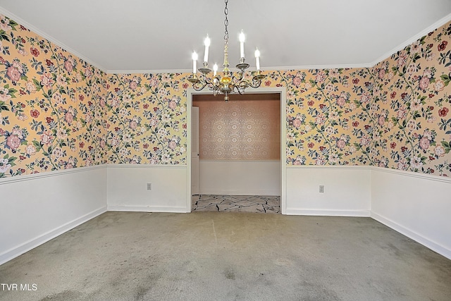 empty room featuring carpet floors, ornamental molding, and a notable chandelier