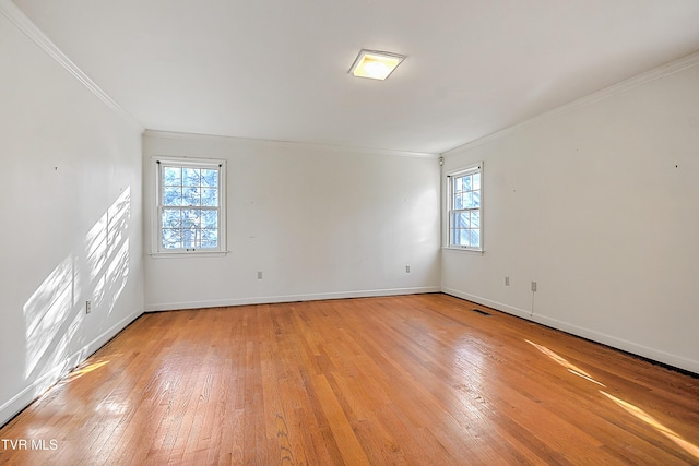 unfurnished room featuring light wood-type flooring, plenty of natural light, and ornamental molding