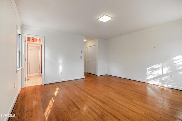 empty room featuring light hardwood / wood-style floors and ornamental molding