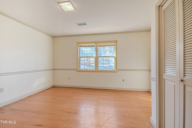 unfurnished room featuring light hardwood / wood-style floors and crown molding