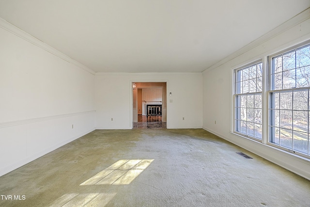 unfurnished living room with a fireplace, carpet flooring, and crown molding