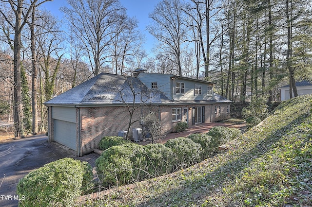 view of home's exterior featuring central air condition unit and a garage