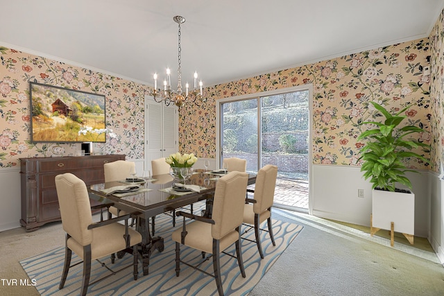 carpeted dining room with an inviting chandelier and crown molding