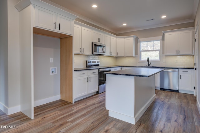 kitchen with white cabinetry, stainless steel appliances, and light hardwood / wood-style flooring