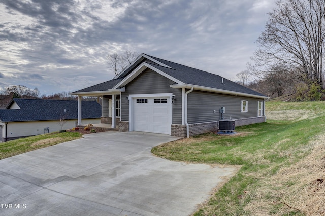 view of front of property with central AC, a front lawn, and a garage