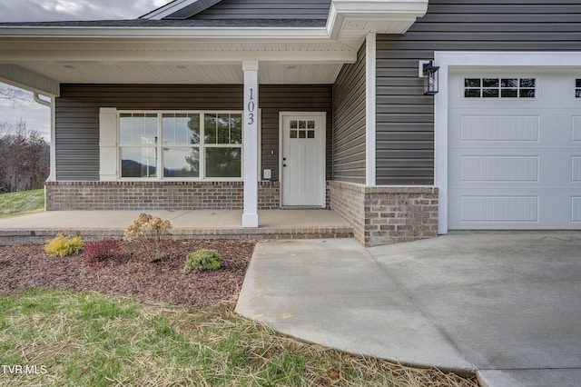 doorway to property featuring a porch and a garage