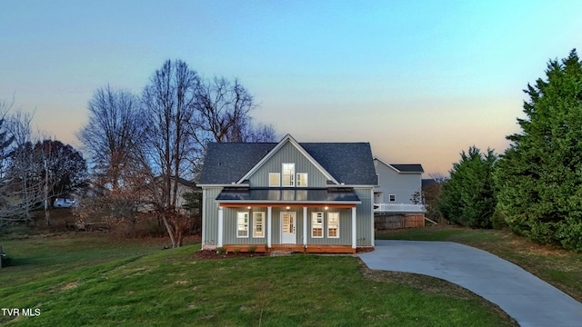 modern farmhouse featuring a porch and a yard