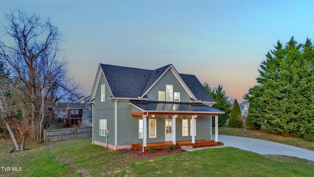 modern farmhouse style home with a lawn and covered porch