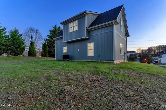 view of side of home featuring central air condition unit and a yard