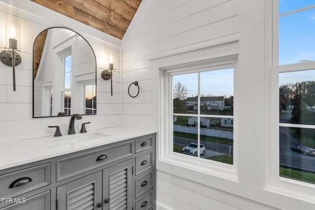 bathroom with wood walls, plenty of natural light, wood ceiling, and lofted ceiling