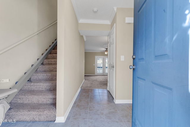 tiled foyer entrance with ceiling fan and crown molding