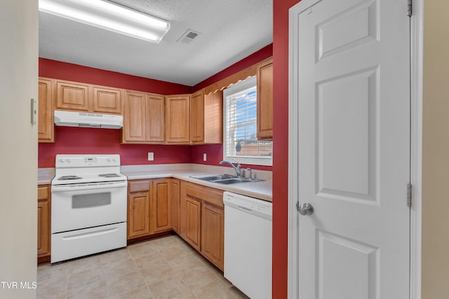 kitchen with a textured ceiling, white appliances, and sink