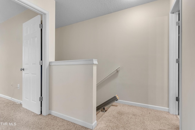 stairway featuring carpet and a textured ceiling