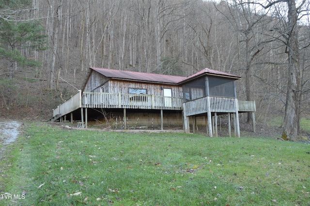 back of house featuring a sunroom, a yard, and a deck