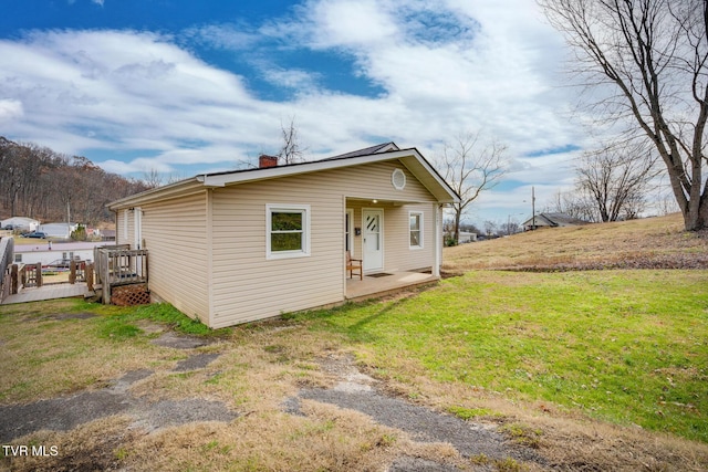 view of front of house with a chimney and a front yard