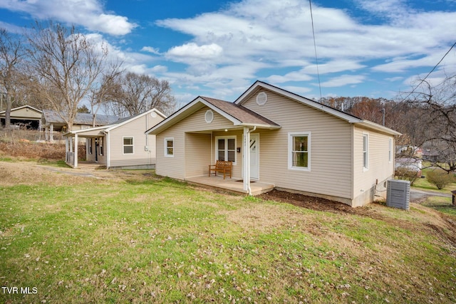 back of house with a lawn, central AC, and a porch