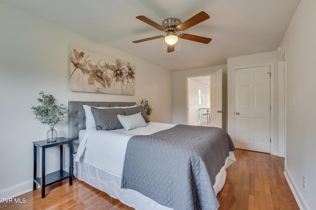 bedroom with a ceiling fan, baseboards, and wood finished floors