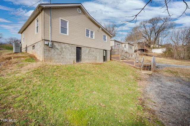 view of side of home with a lawn and a wooden deck