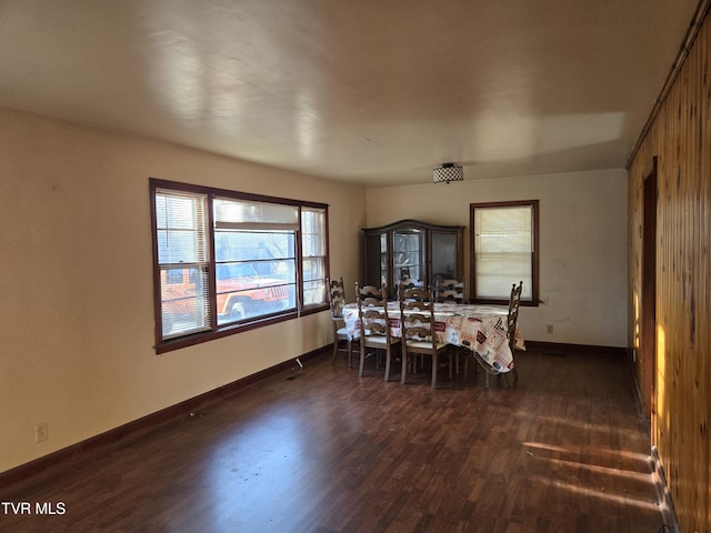 dining area featuring dark wood-type flooring and baseboards