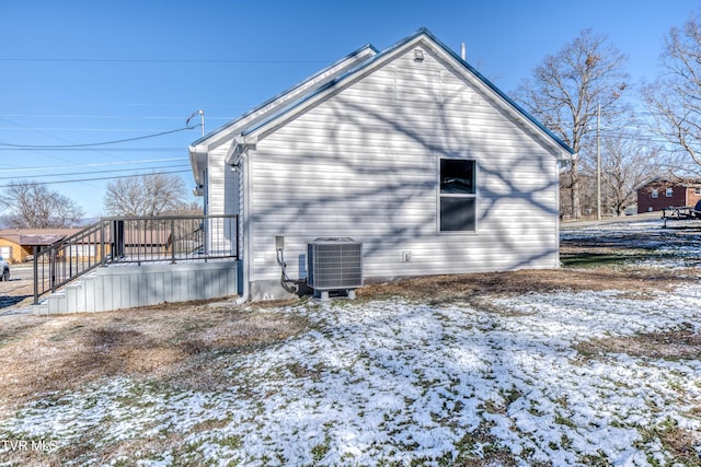 view of snowy exterior featuring cooling unit and a wooden deck