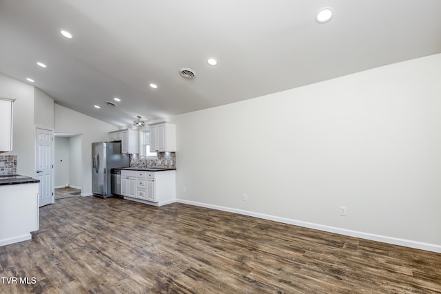 kitchen with decorative backsplash, dark hardwood / wood-style flooring, white cabinetry, and stainless steel appliances