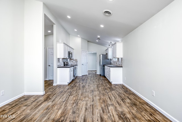 kitchen featuring sink, dark wood-type flooring, decorative backsplash, white cabinets, and appliances with stainless steel finishes