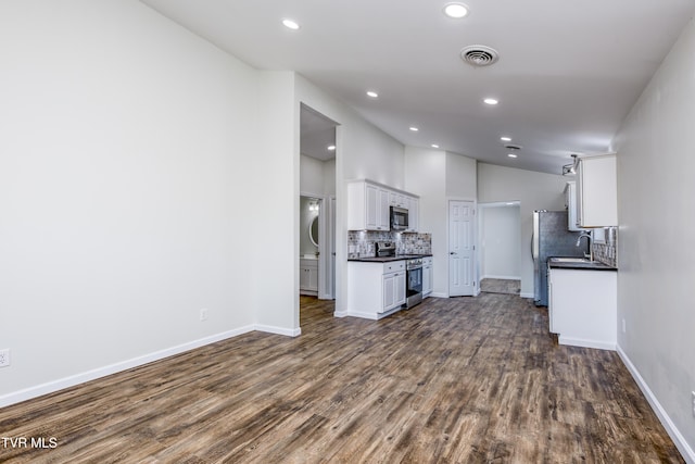 kitchen with white cabinets, stainless steel appliances, and dark wood-type flooring