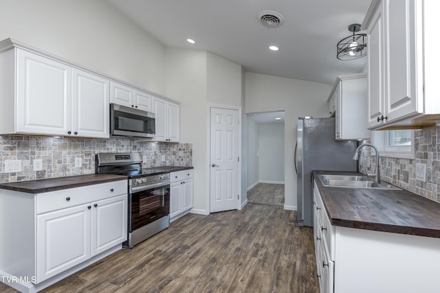 kitchen featuring sink, butcher block countertops, dark hardwood / wood-style flooring, white cabinetry, and stainless steel appliances