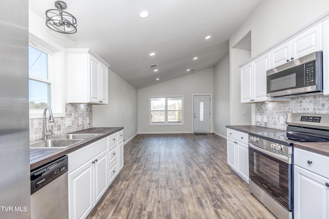 kitchen with white cabinets, stainless steel appliances, tasteful backsplash, and sink