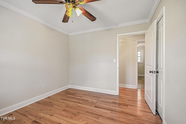 unfurnished room featuring a textured ceiling, light wood-type flooring, ceiling fan, and crown molding