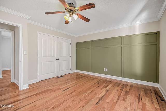 unfurnished bedroom featuring a textured ceiling, light hardwood / wood-style flooring, ceiling fan, and ornamental molding