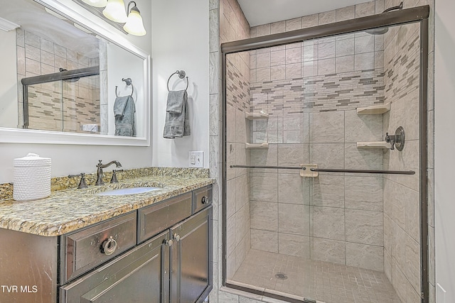 bathroom with vanity and a shower with shower door