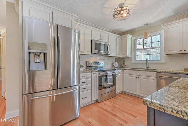 kitchen featuring sink, white cabinetry, stainless steel appliances, and light hardwood / wood-style flooring