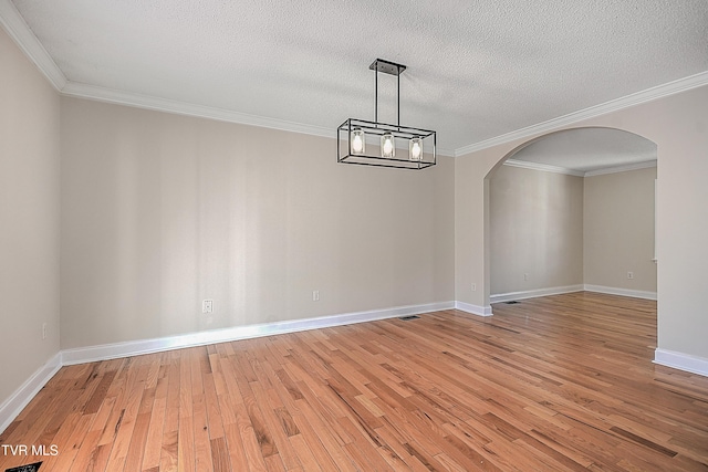 unfurnished dining area with hardwood / wood-style flooring, ornamental molding, and a textured ceiling