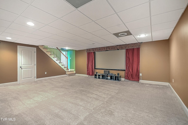 carpeted home theater room with a paneled ceiling