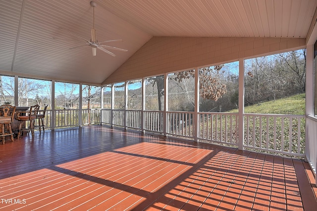 unfurnished sunroom with ceiling fan, a wealth of natural light, and vaulted ceiling