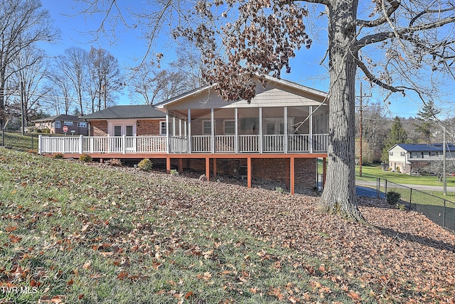 back of house with a sunroom and a deck