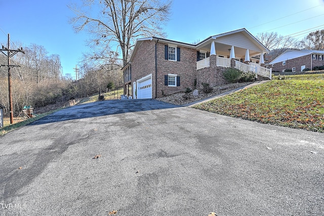 view of property exterior with covered porch and a garage