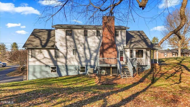 back of property featuring a lawn and a deck